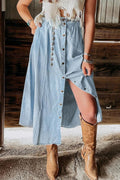 Woman wearing a light blue button-down midi skirt with a front slit.