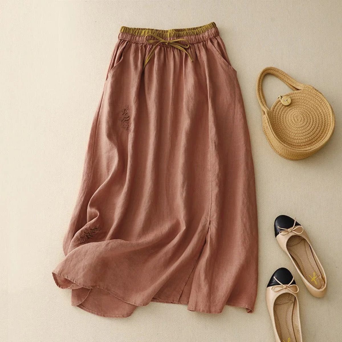 Light beige midi skirt with drawstring waist and embroidery.