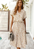 Woman in a spot print midi shirt dress with short sleeves and drawstring waist.