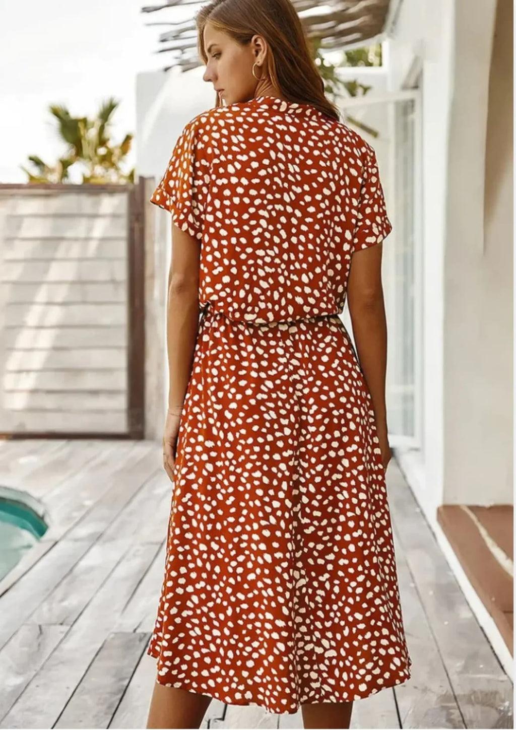 Woman in a spot print midi shirt dress with short sleeves and drawstring waist.