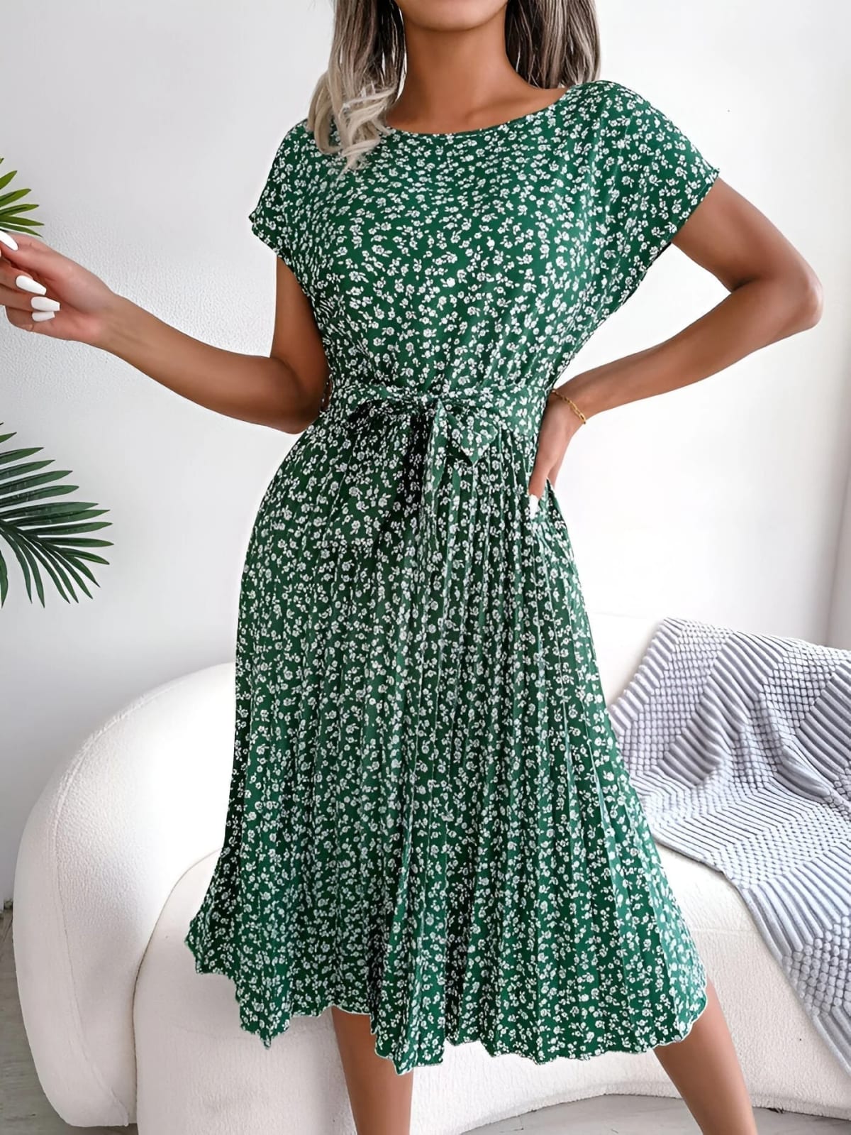 A-line dress with pleated skirt and floral pattern, worn outdoors.