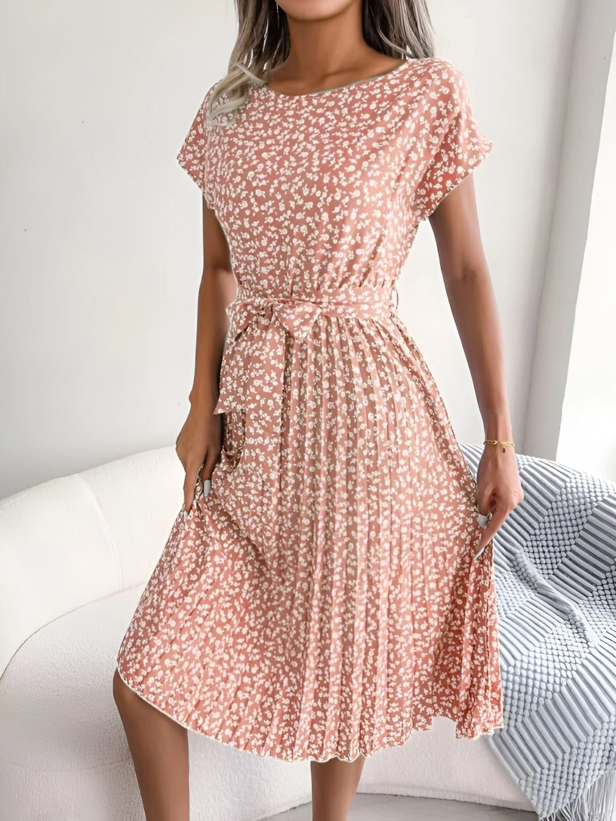 A-line dress with pleated skirt and floral pattern, worn outdoors.