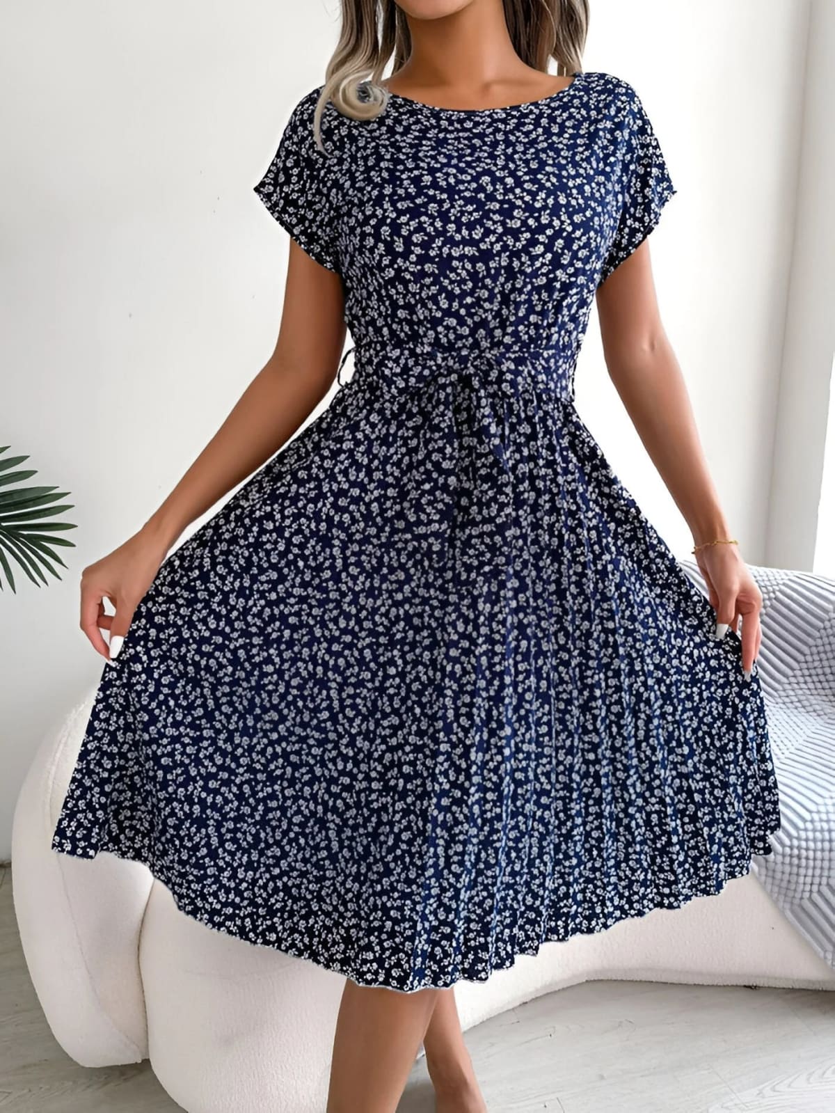 A-line dress with pleated skirt and floral pattern, worn outdoors.
