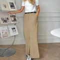 Woman wearing high-waisted straight-cut maxi skirt with front slit.