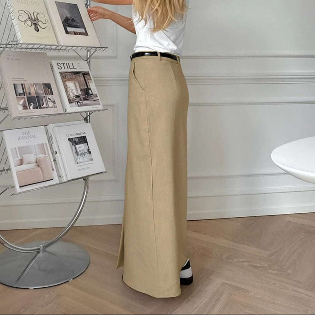 Woman wearing high-waisted straight-cut maxi skirt with front slit.