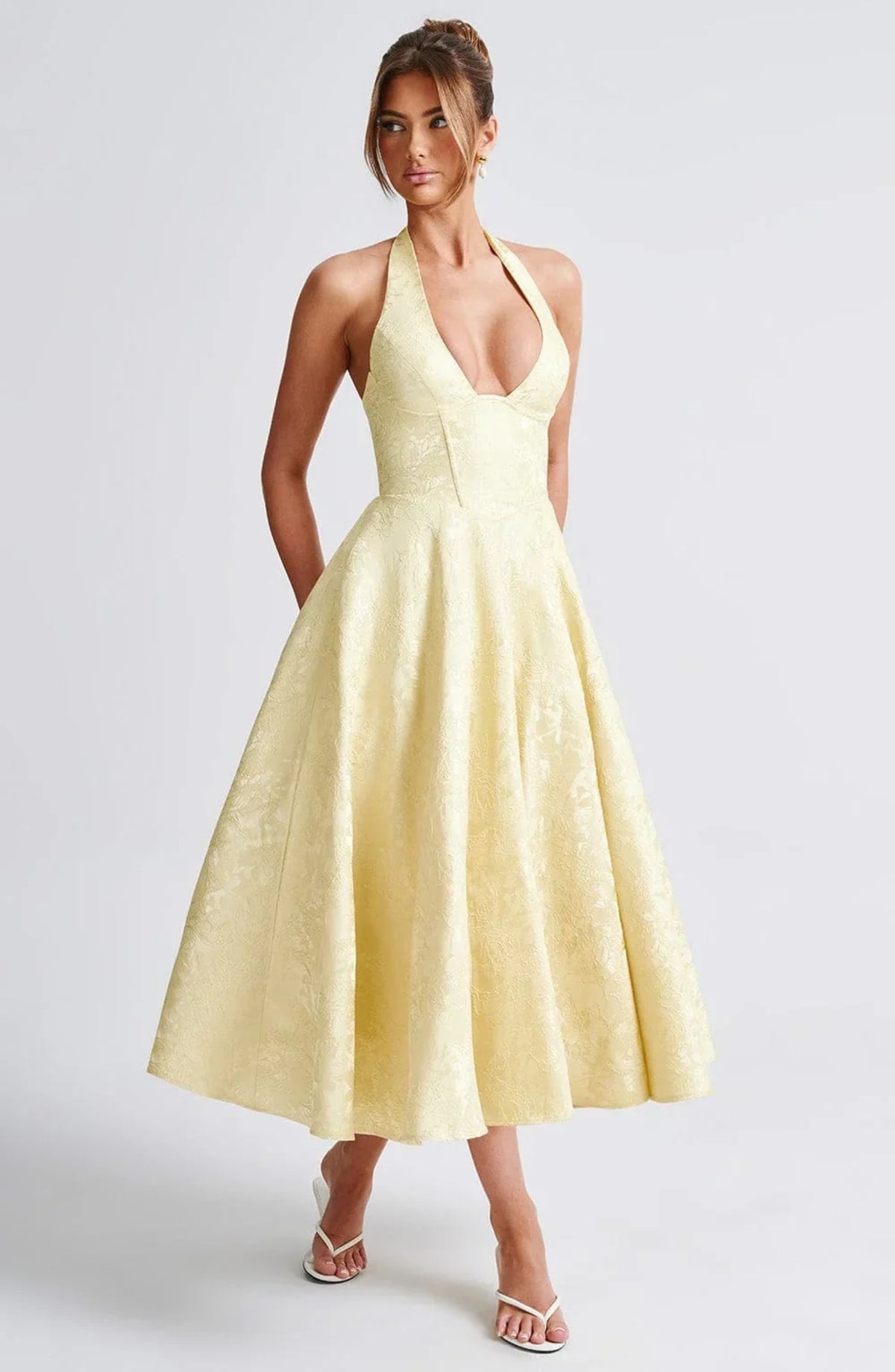 Woman in halter neck midi dress with deep V-neckline and flared skirt