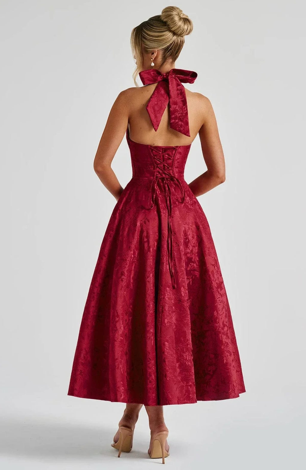 Woman in halter neck midi dress with deep V-neckline and flared skirt