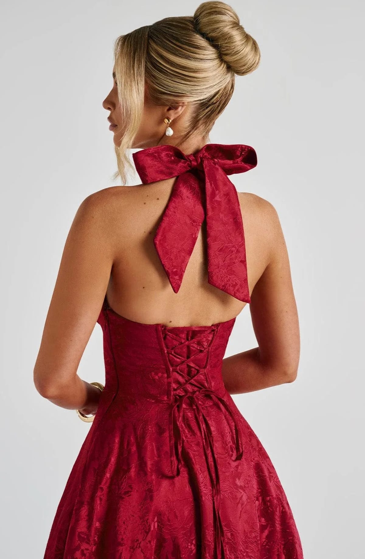Woman in halter neck midi dress with deep V-neckline and flared skirt