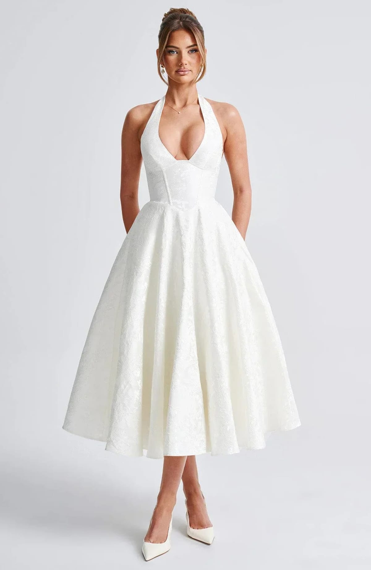Woman in halter neck midi dress with deep V-neckline and flared skirt