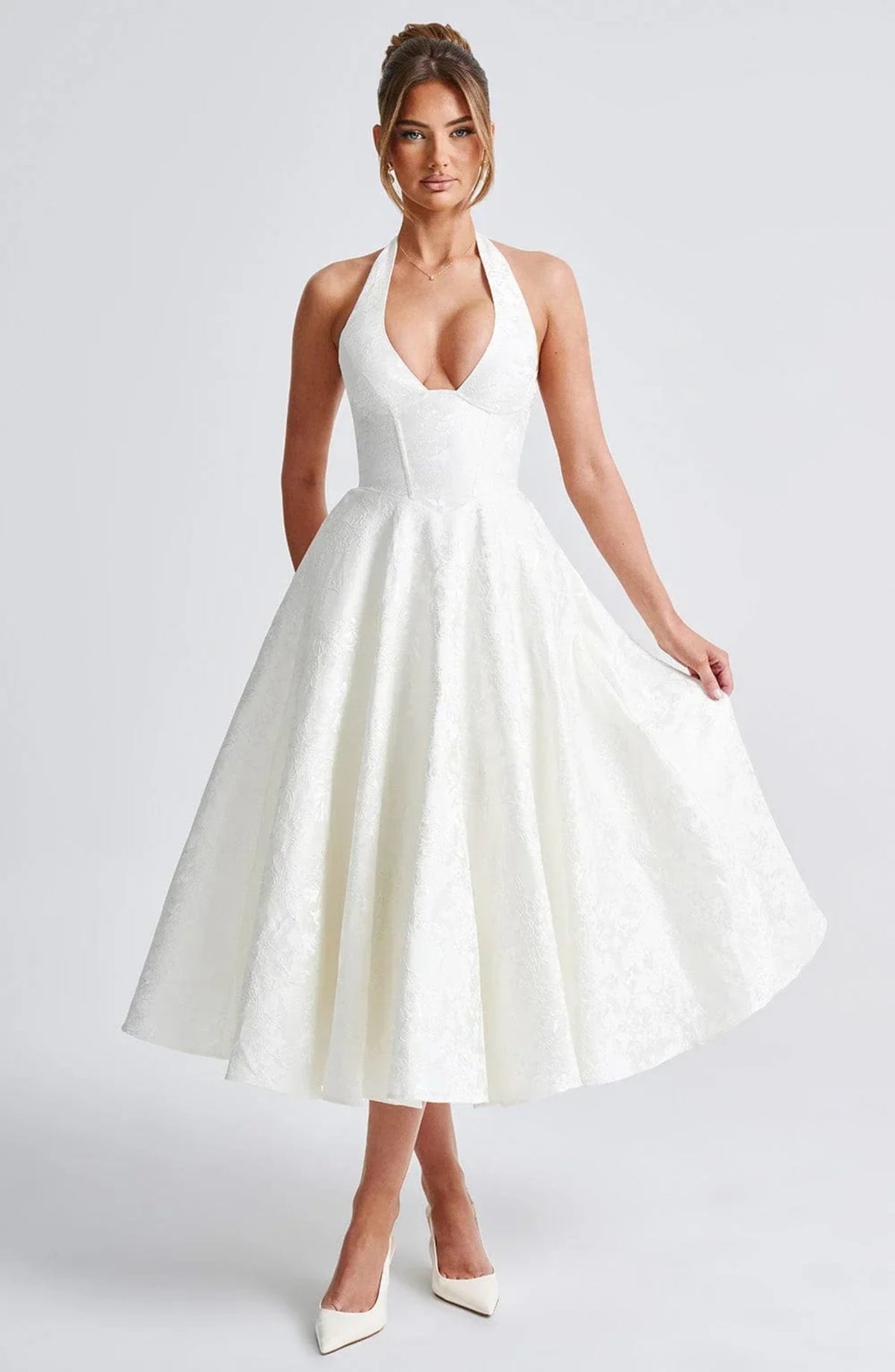 Woman in halter neck midi dress with deep V-neckline and flared skirt
