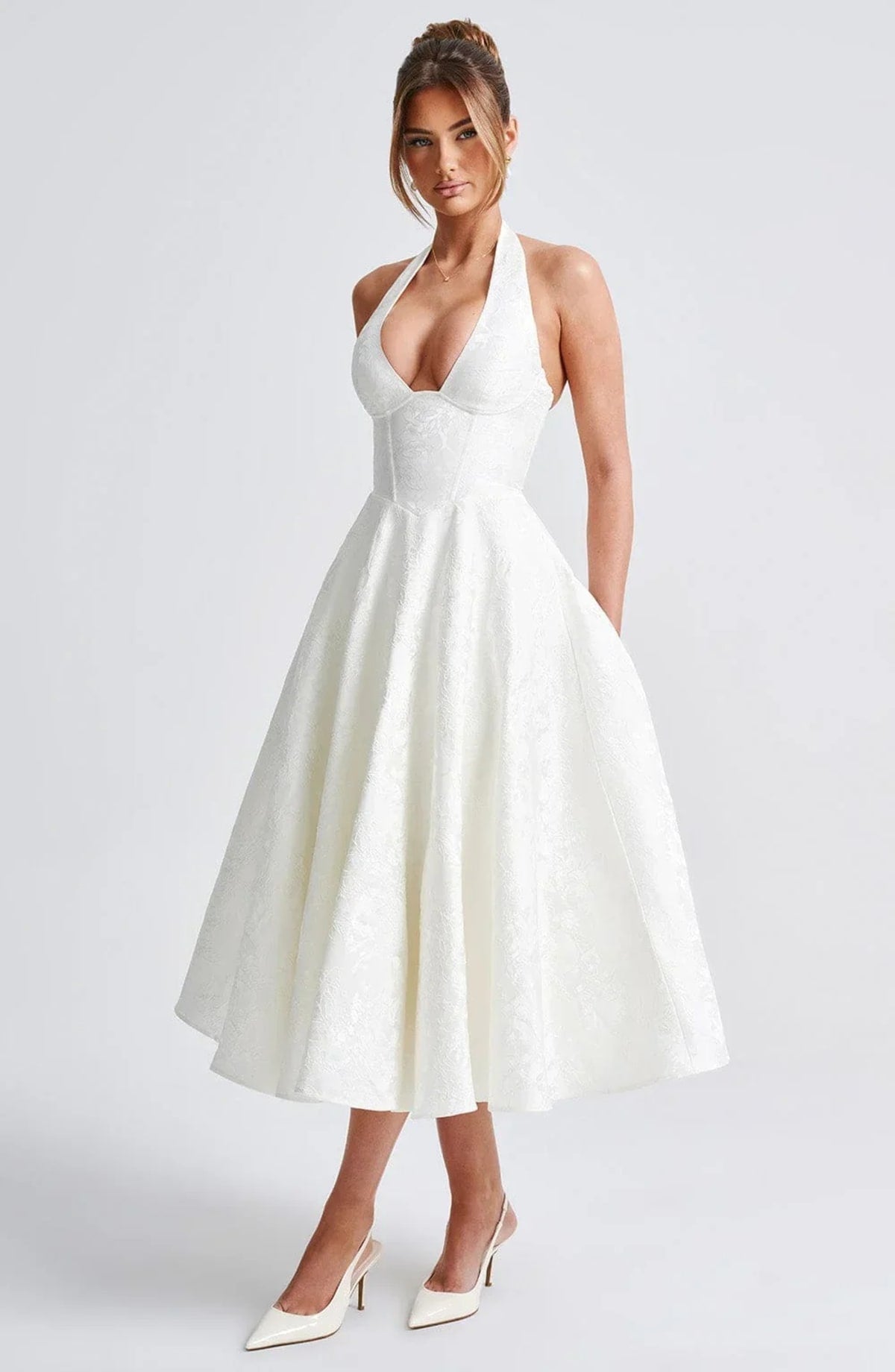 Woman in halter neck midi dress with deep V-neckline and flared skirt