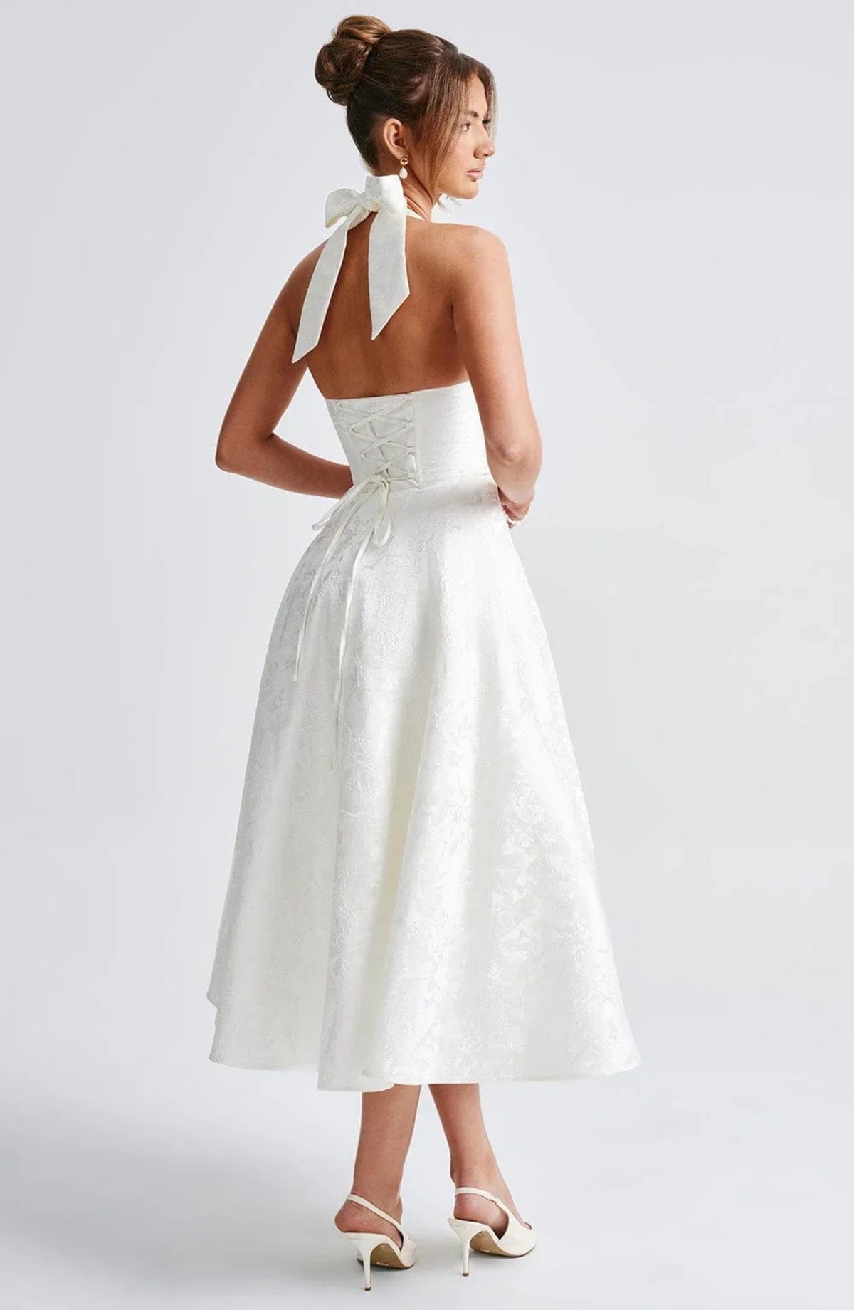 Woman in halter neck midi dress with deep V-neckline and flared skirt