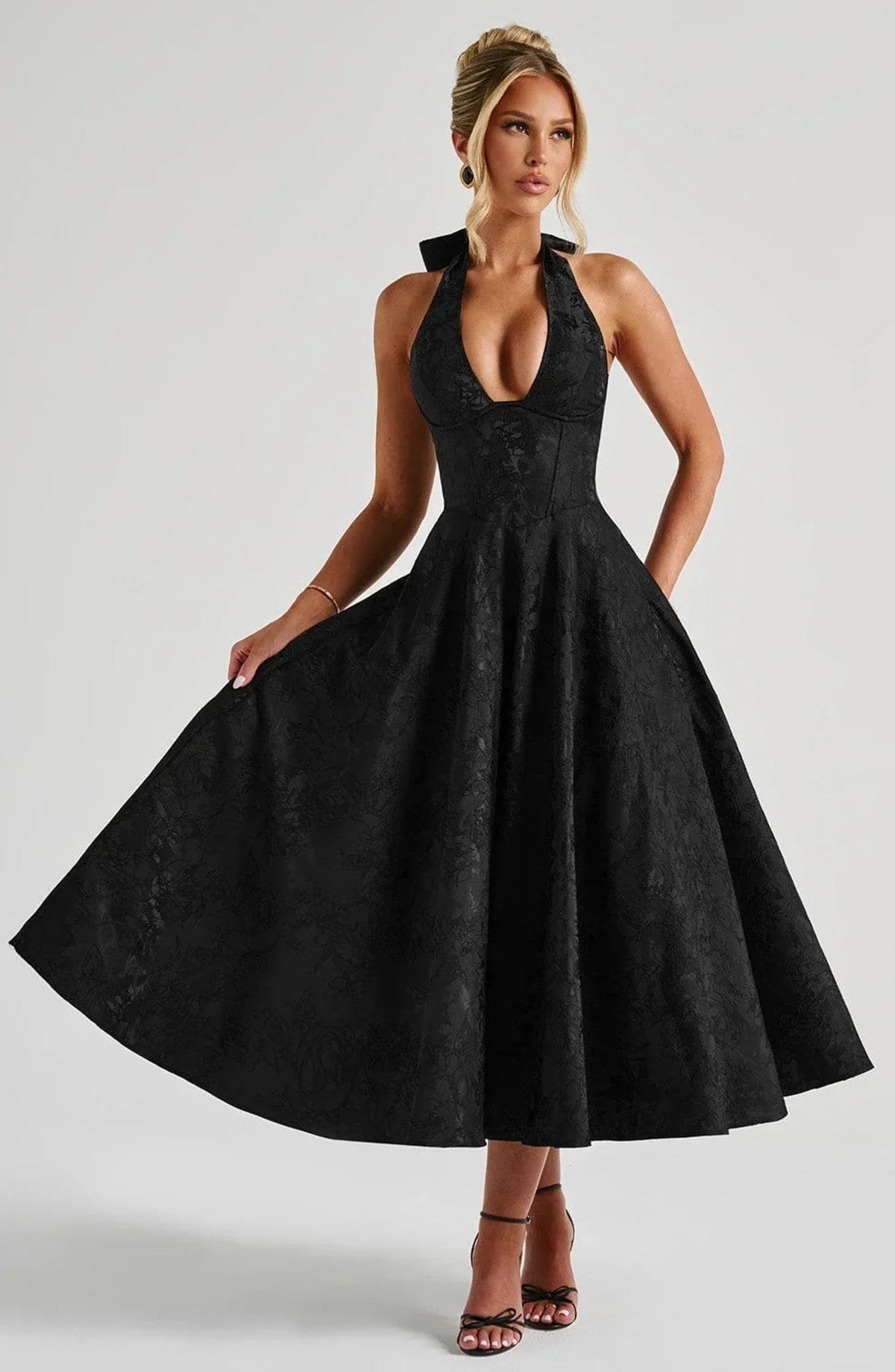 Woman in halter neck midi dress with deep V-neckline and flared skirt