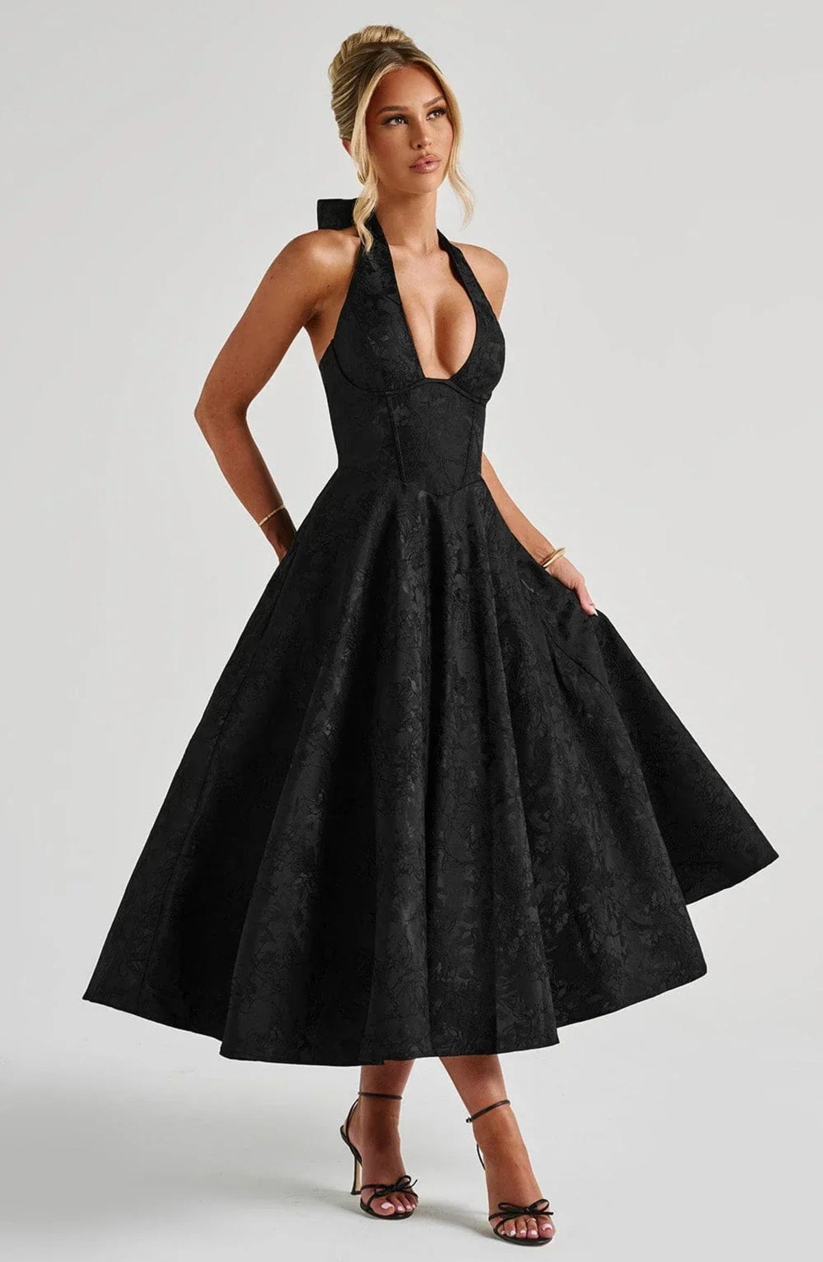 Woman in halter neck midi dress with deep V-neckline and flared skirt