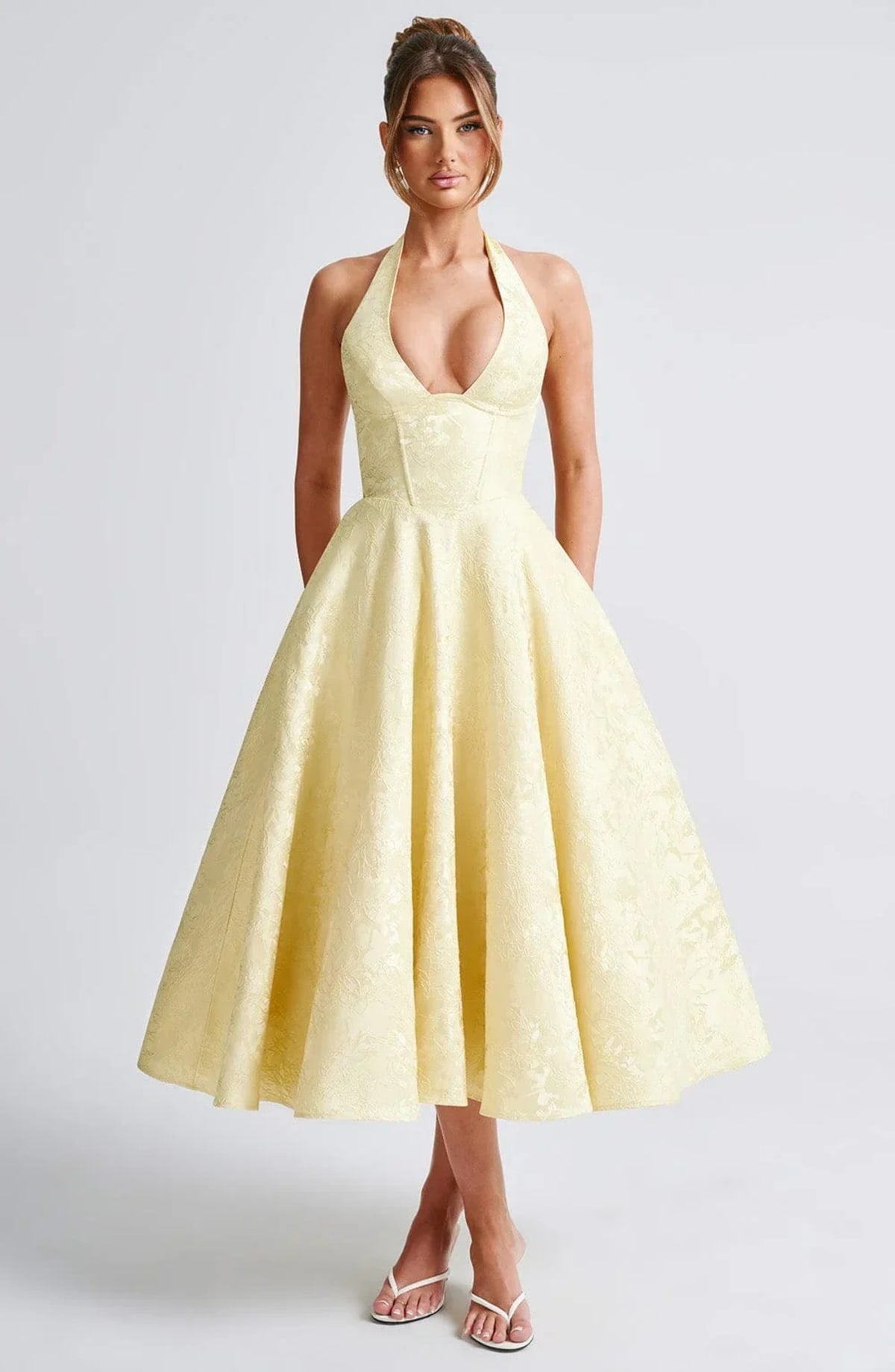 Woman in halter neck midi dress with deep V-neckline and flared skirt