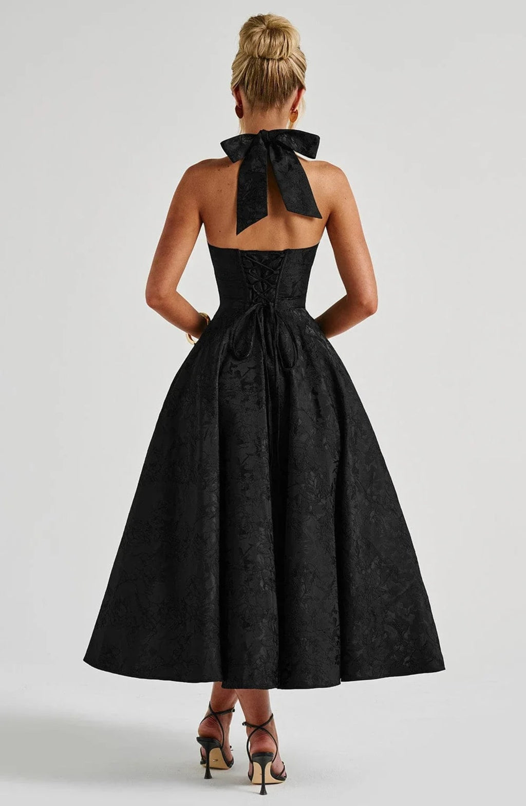 Woman in halter neck midi dress with deep V-neckline and flared skirt