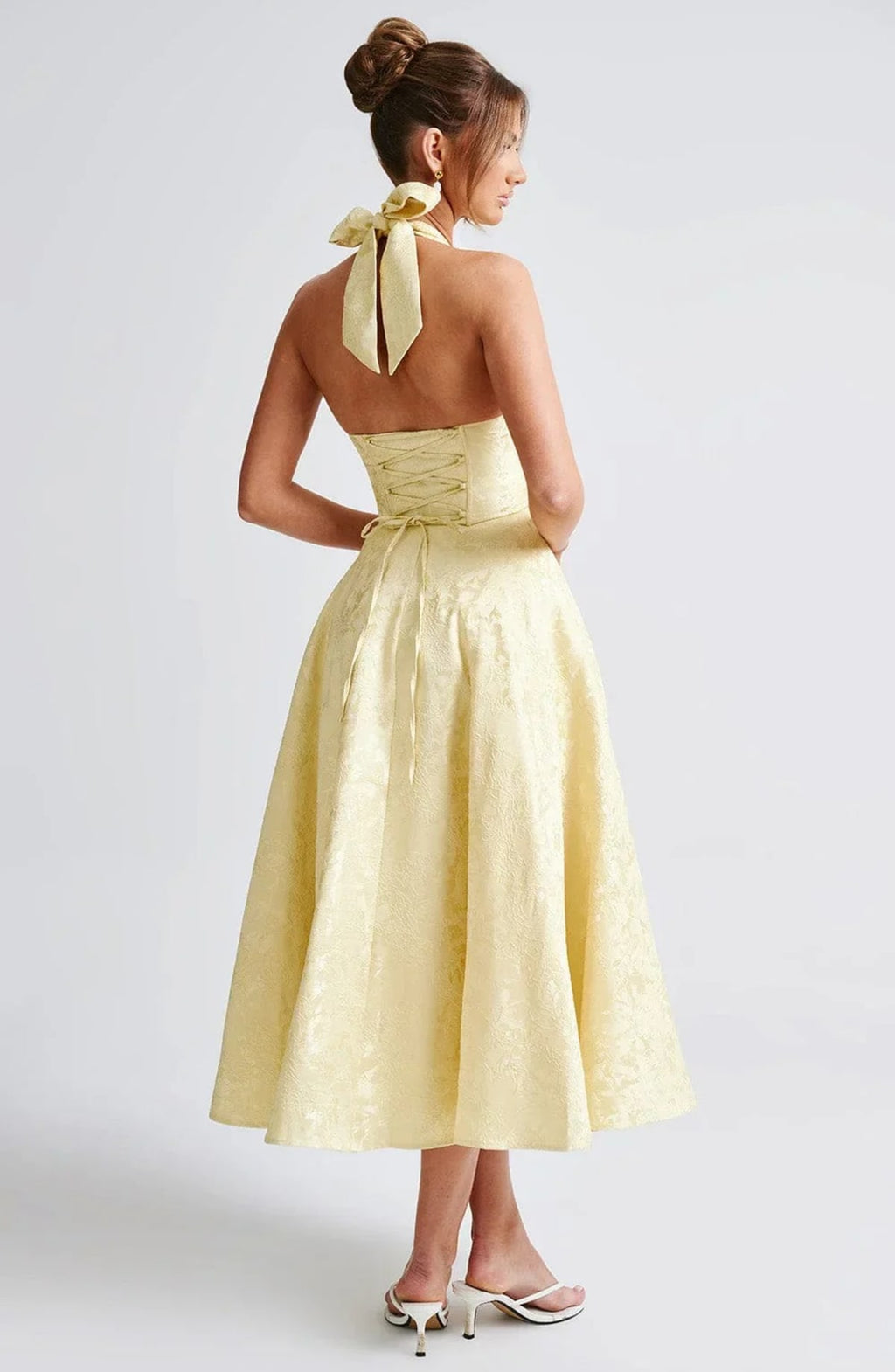 Woman in halter neck midi dress with deep V-neckline and flared skirt