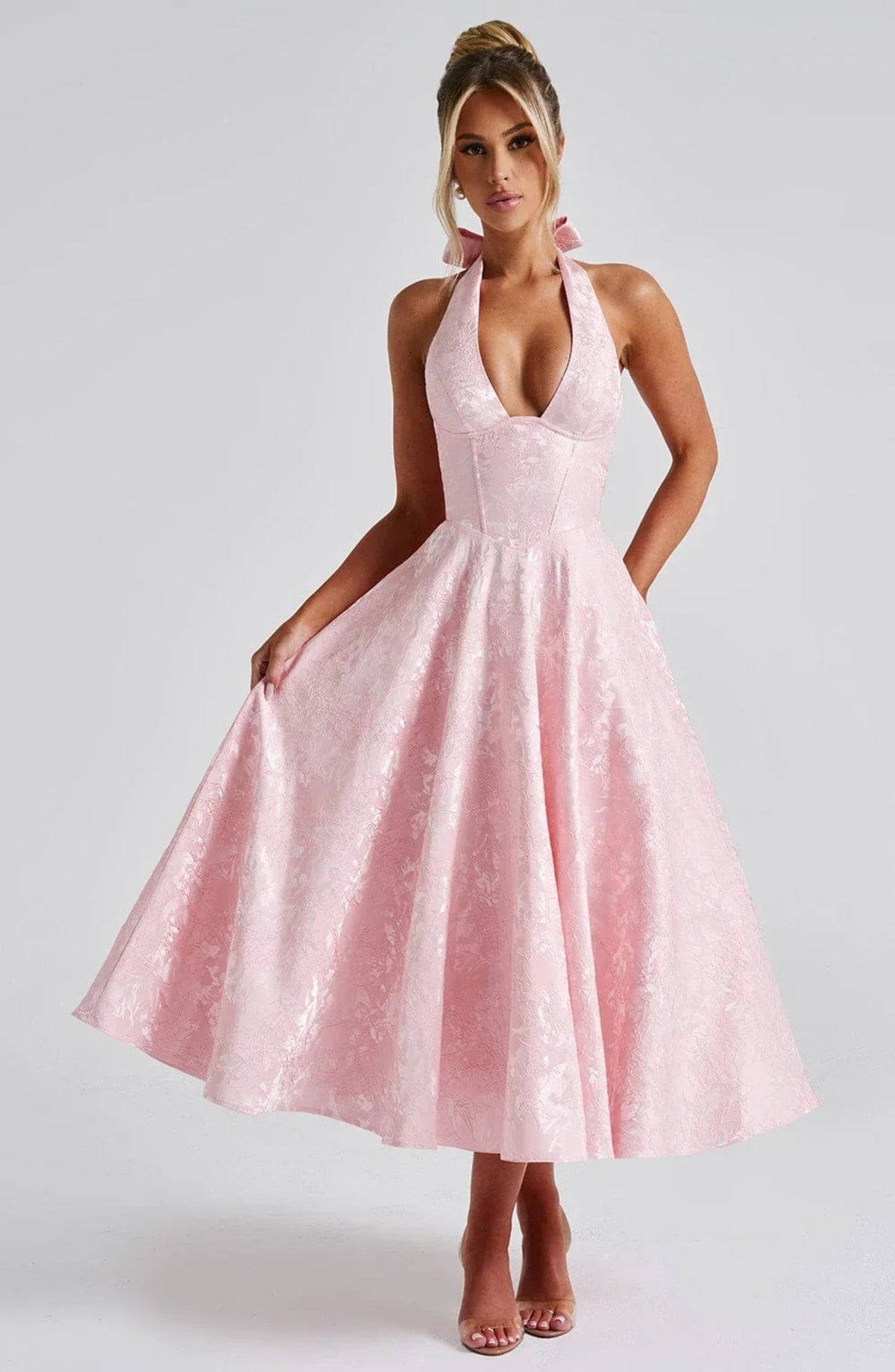 Woman in halter neck midi dress with deep V-neckline and flared skirt