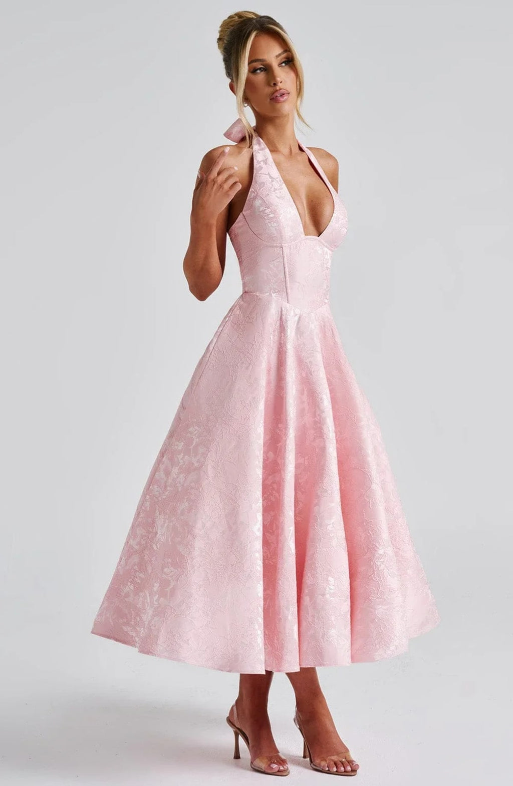 Woman in halter neck midi dress with deep V-neckline and flared skirt