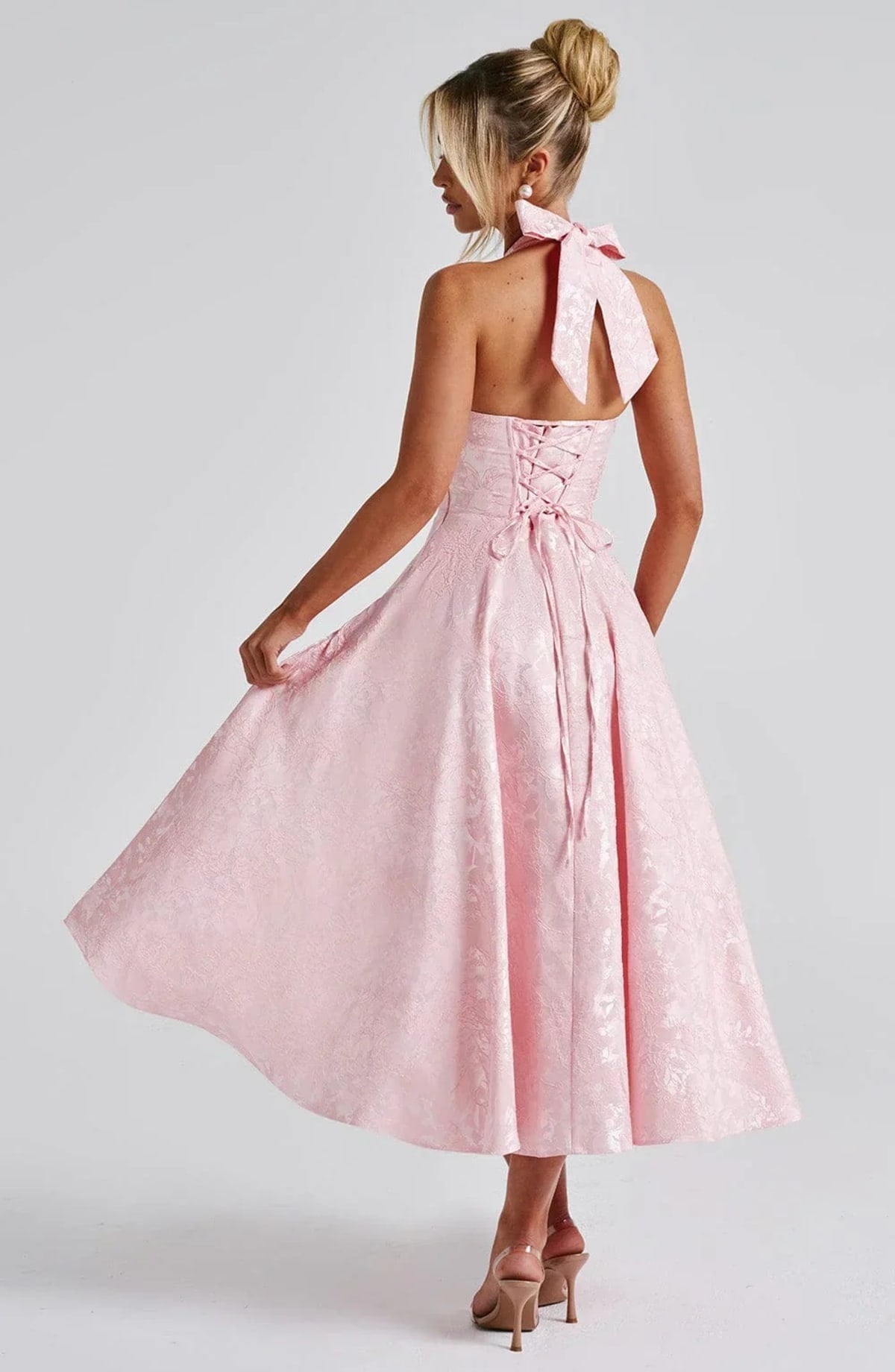Woman in halter neck midi dress with deep V-neckline and flared skirt