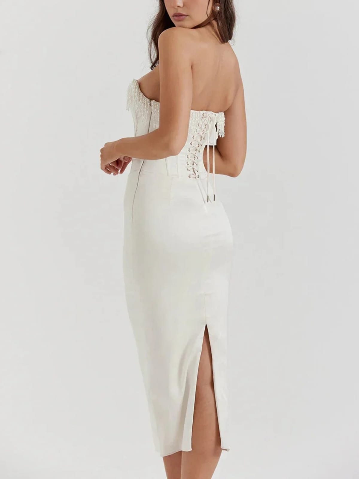 Woman wearing strapless midi dress with pearl and beaded fringe.