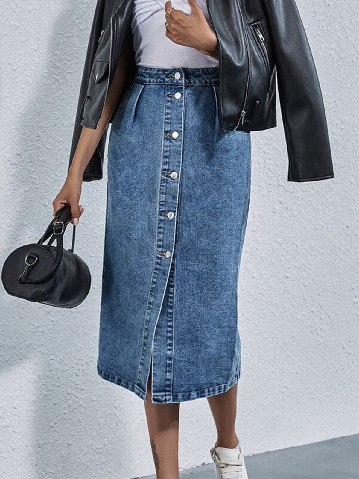 Woman wearing pleated denim midi skirt with buttons.