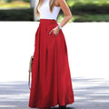 Woman wearing a vibrant red pleated high-waisted maxi skirt.