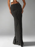 Woman wearing a polka dot maxi skirt with a flared hem.