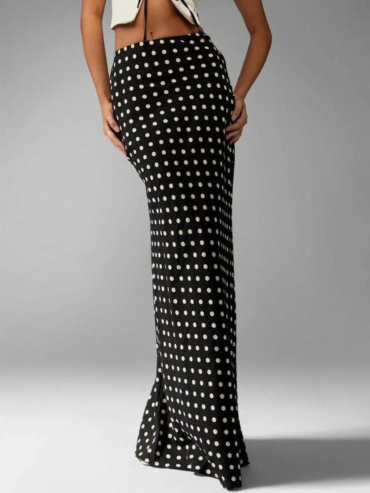 Woman wearing a polka dot maxi skirt with a flared hem.