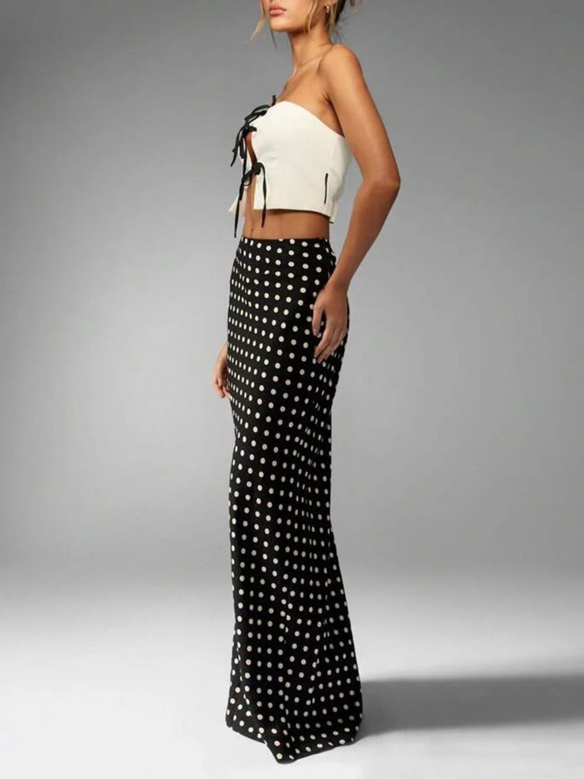 Woman wearing a polka dot maxi skirt with a flared hem.