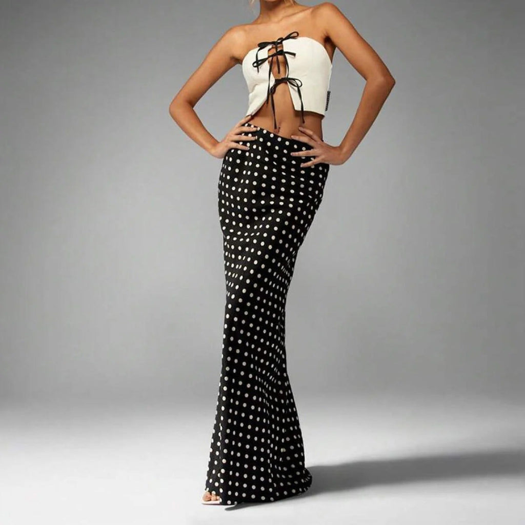 Woman wearing a polka dot maxi skirt with a flared hem.