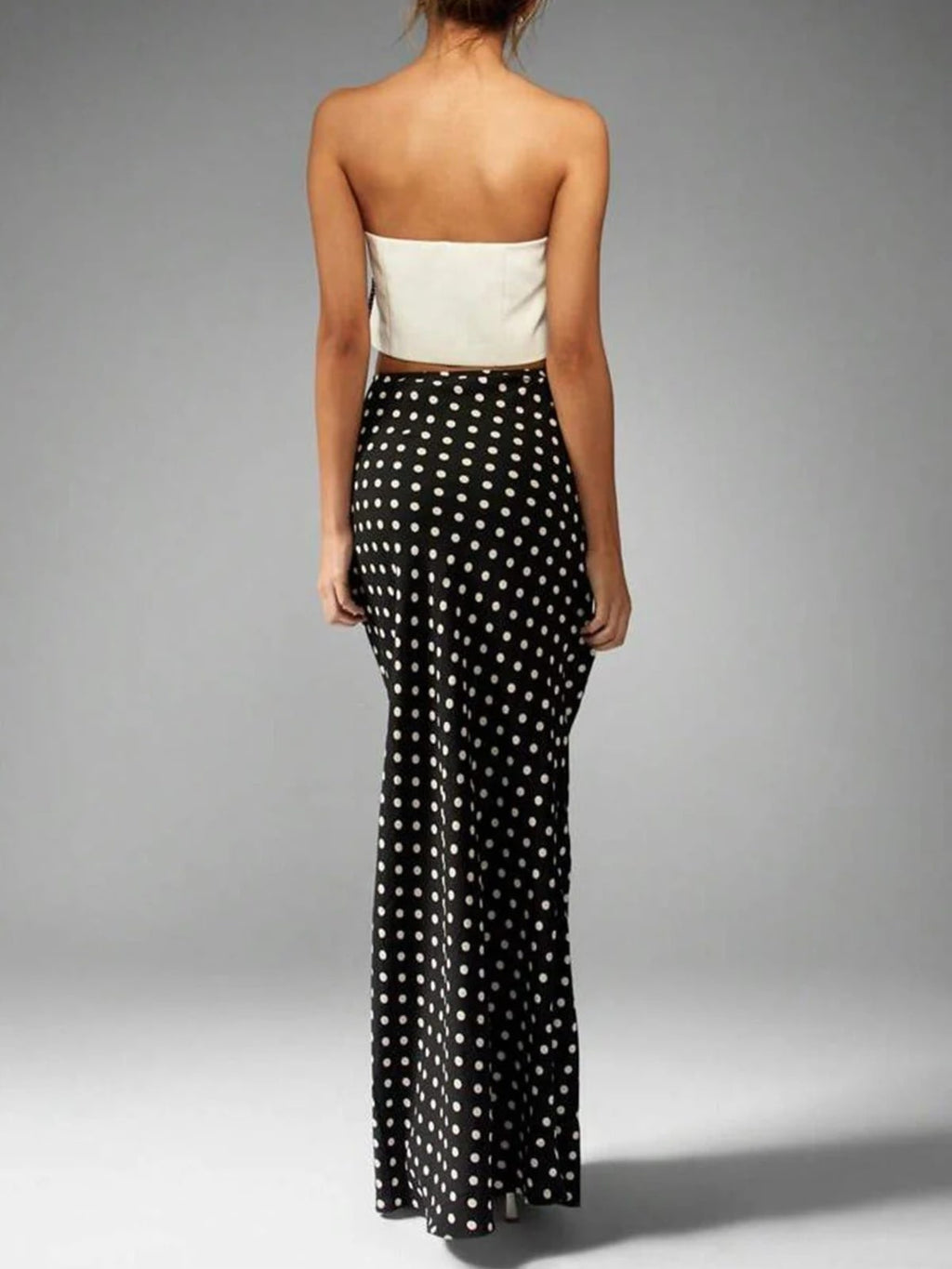 Woman wearing a polka dot maxi skirt with a flared hem.