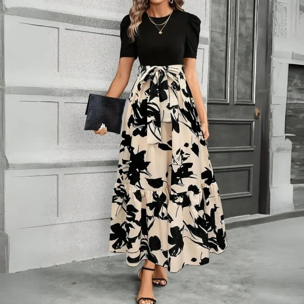 Women's maxi dress with puff sleeves, tie waist, and ruffle hem.