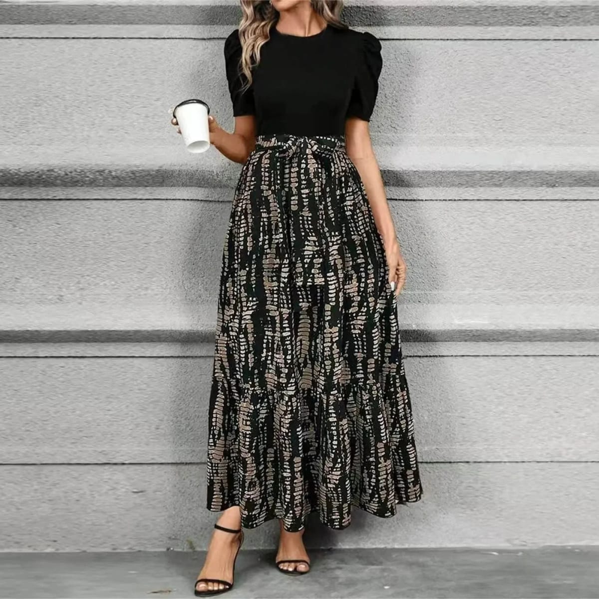 Women's maxi dress with puff sleeves, tie waist, and ruffle hem.