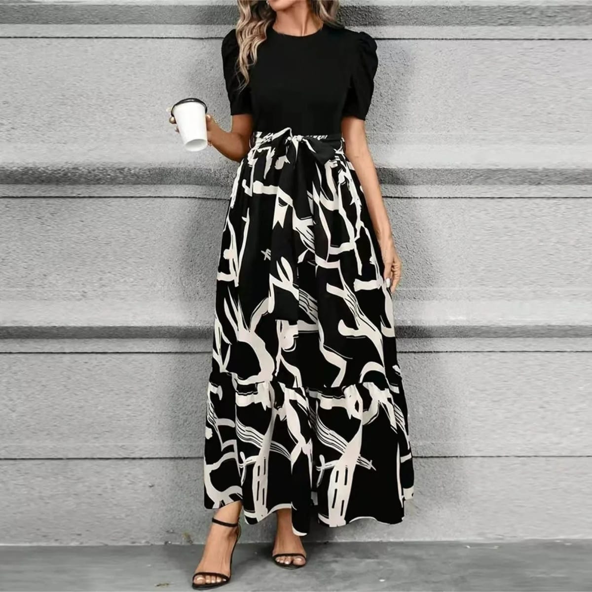 Women's maxi dress with puff sleeves, tie waist, and ruffle hem.