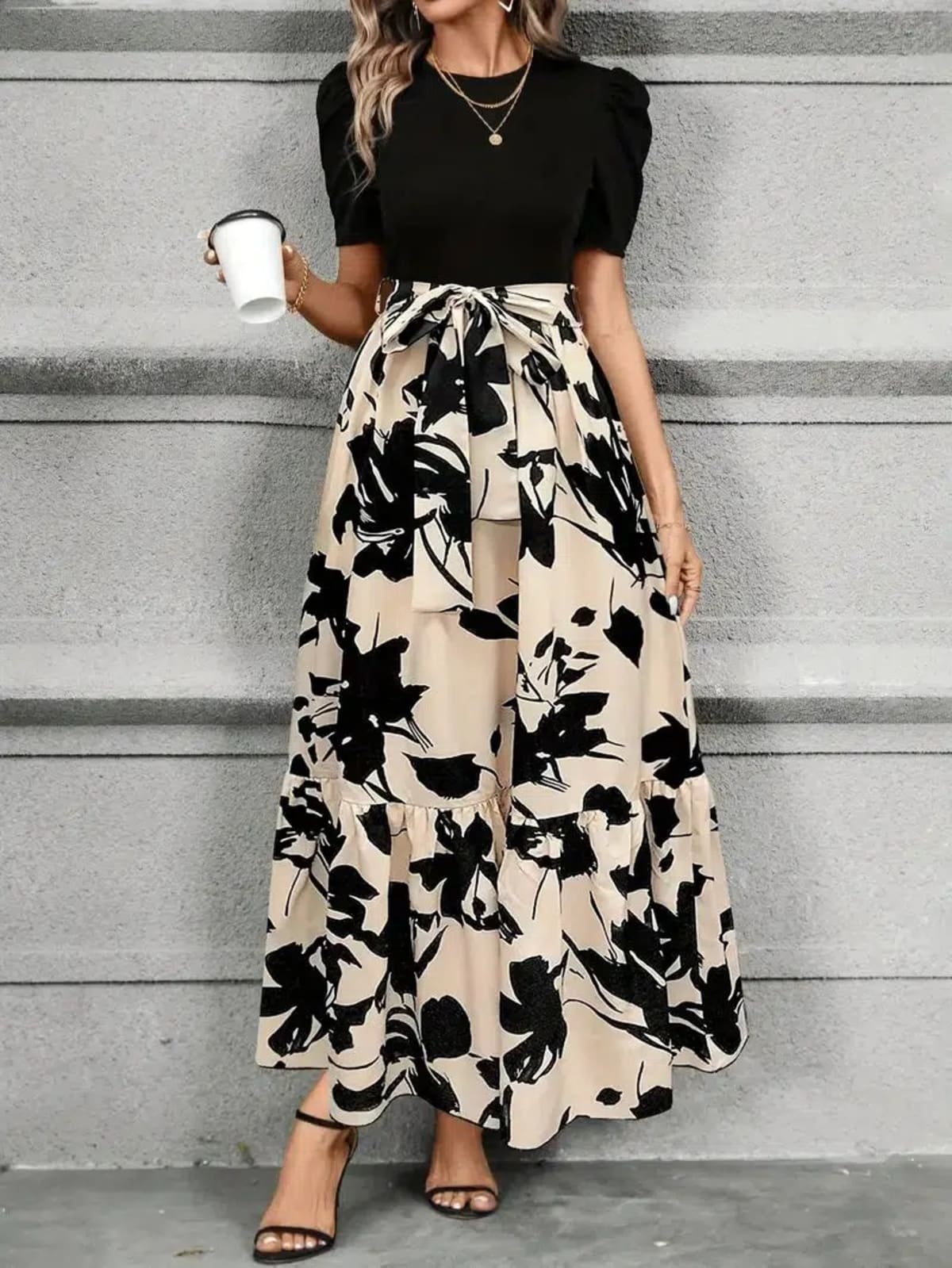 Women's maxi dress with puff sleeves, tie waist, and ruffle hem.