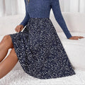 Woman wearing ribbed knit floral A-line midi dress, seated.