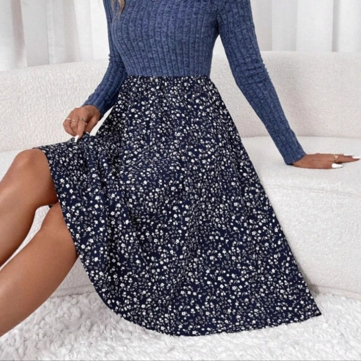 Woman wearing ribbed knit floral A-line midi dress, seated.
