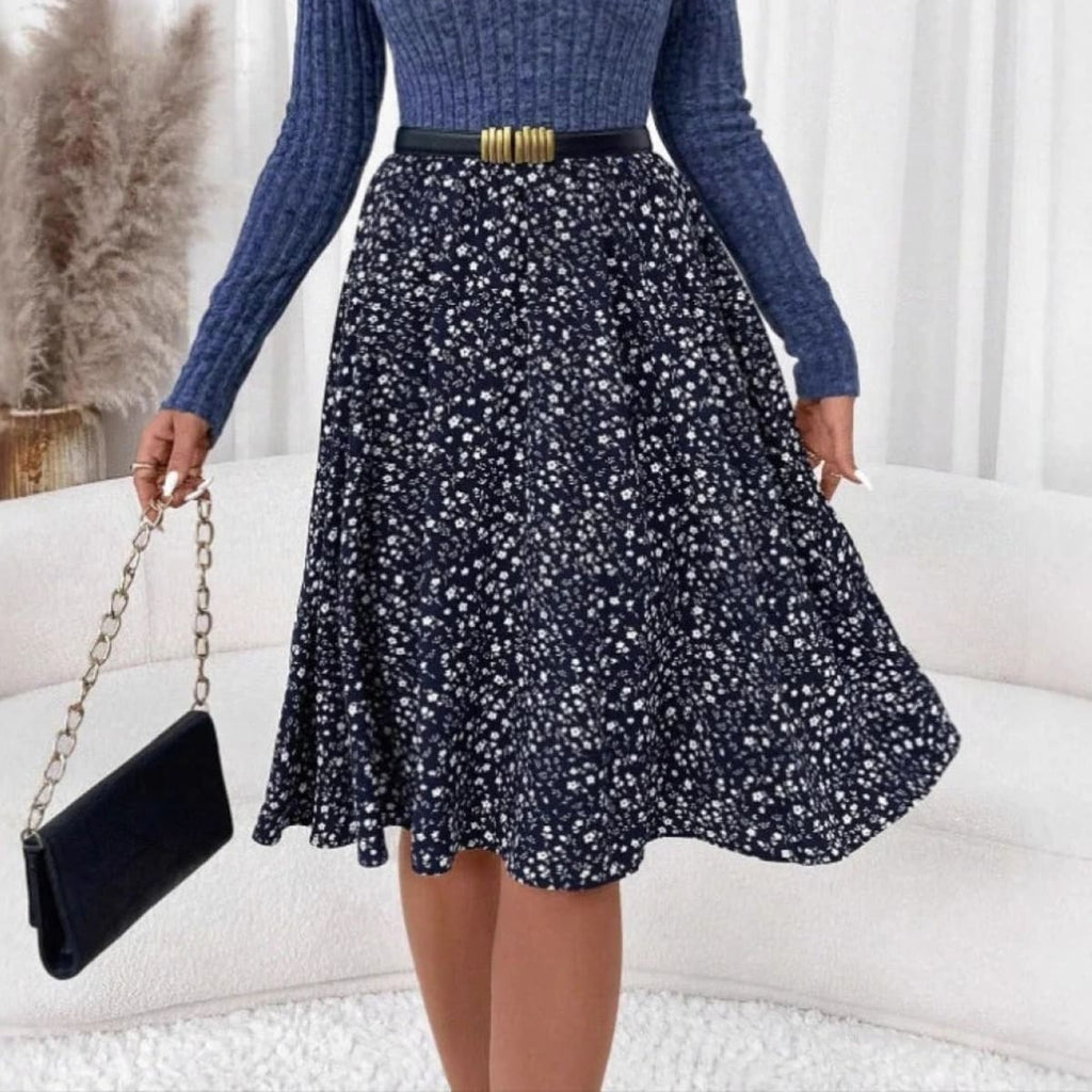 Woman wearing ribbed knit floral A-line midi dress, seated.