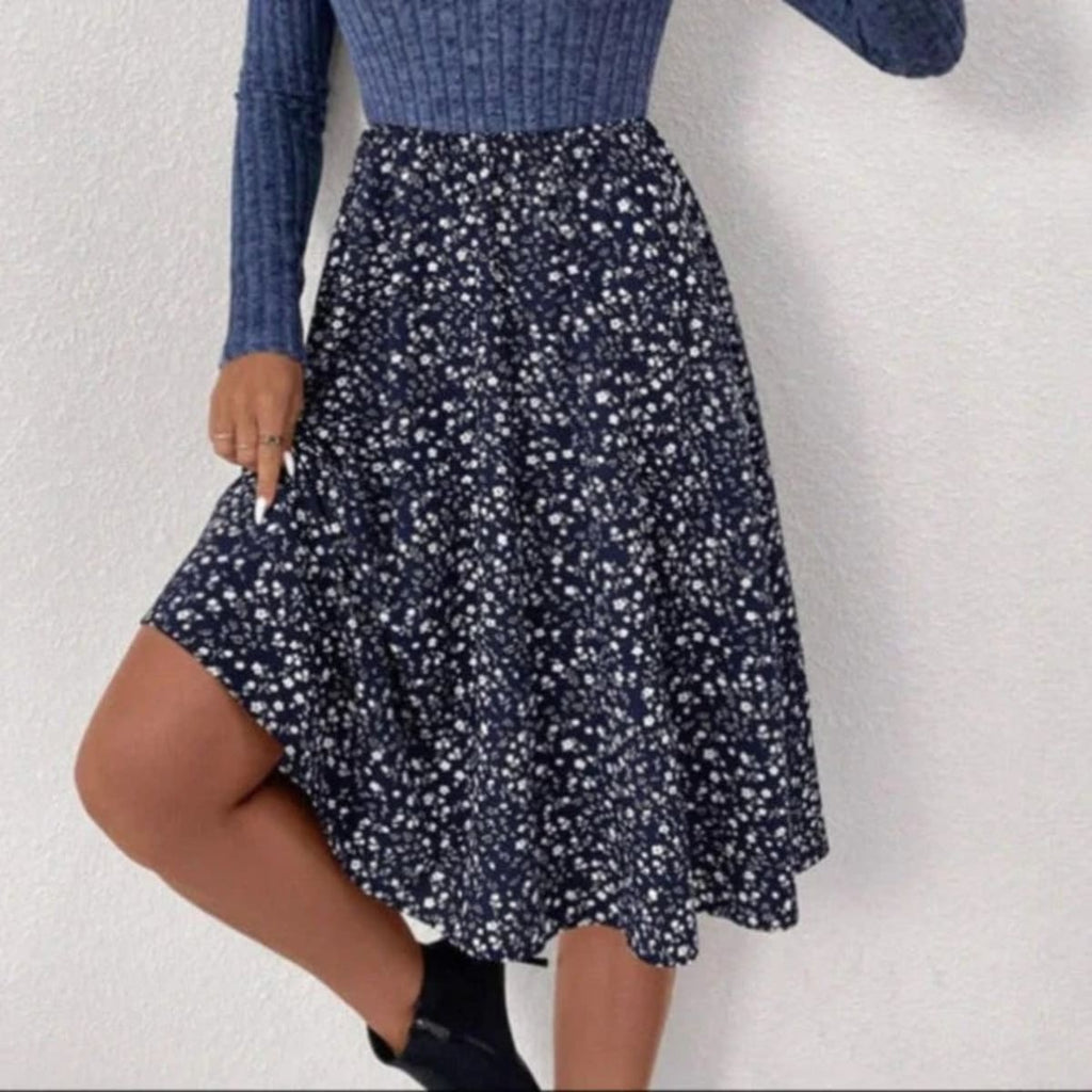 Woman wearing ribbed knit floral A-line midi dress, seated.