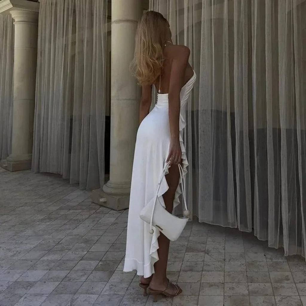 Woman on staircase wearing asymmetrical ruffled halter maxi dress