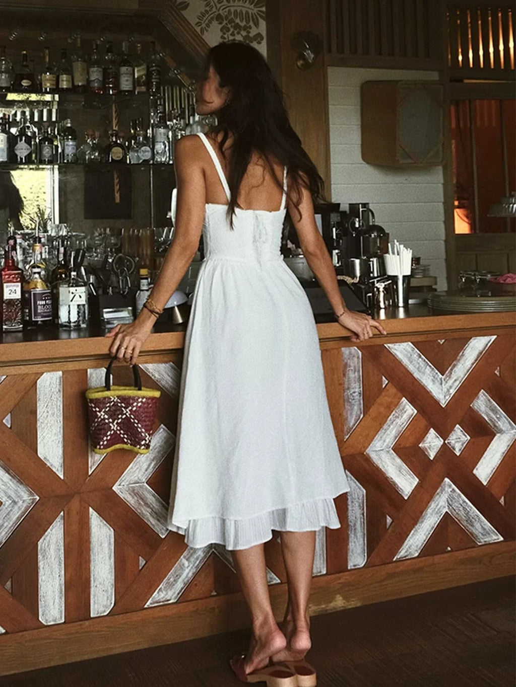 Woman in white midi dress with ruffled hem indoors
