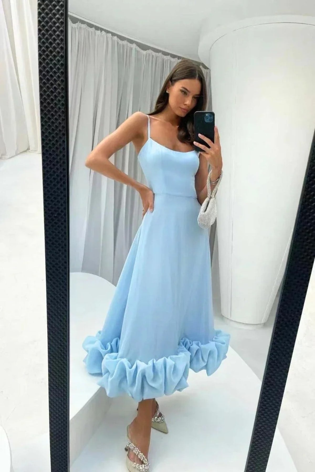 Woman in spaghetti strap midi dress with ruffled hem and fitted bodice.