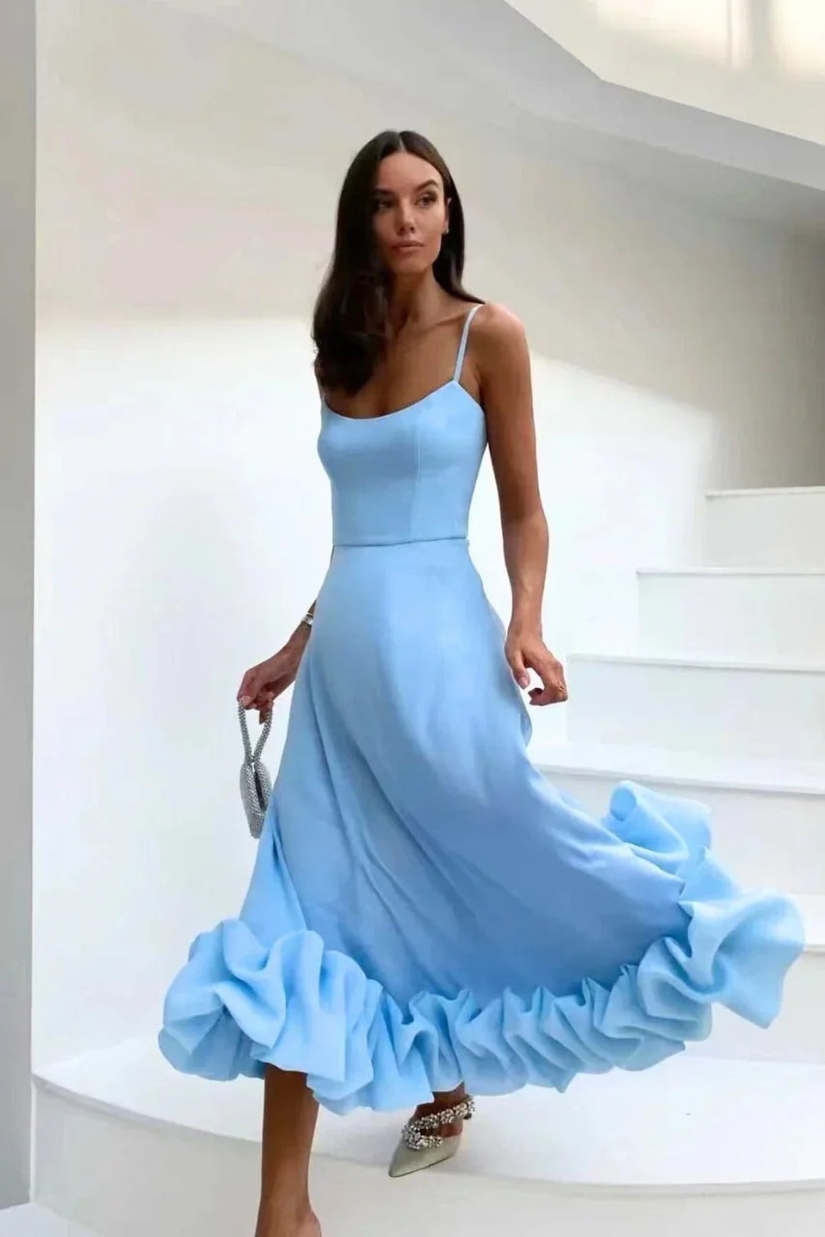 Woman in spaghetti strap midi dress with ruffled hem and fitted bodice.