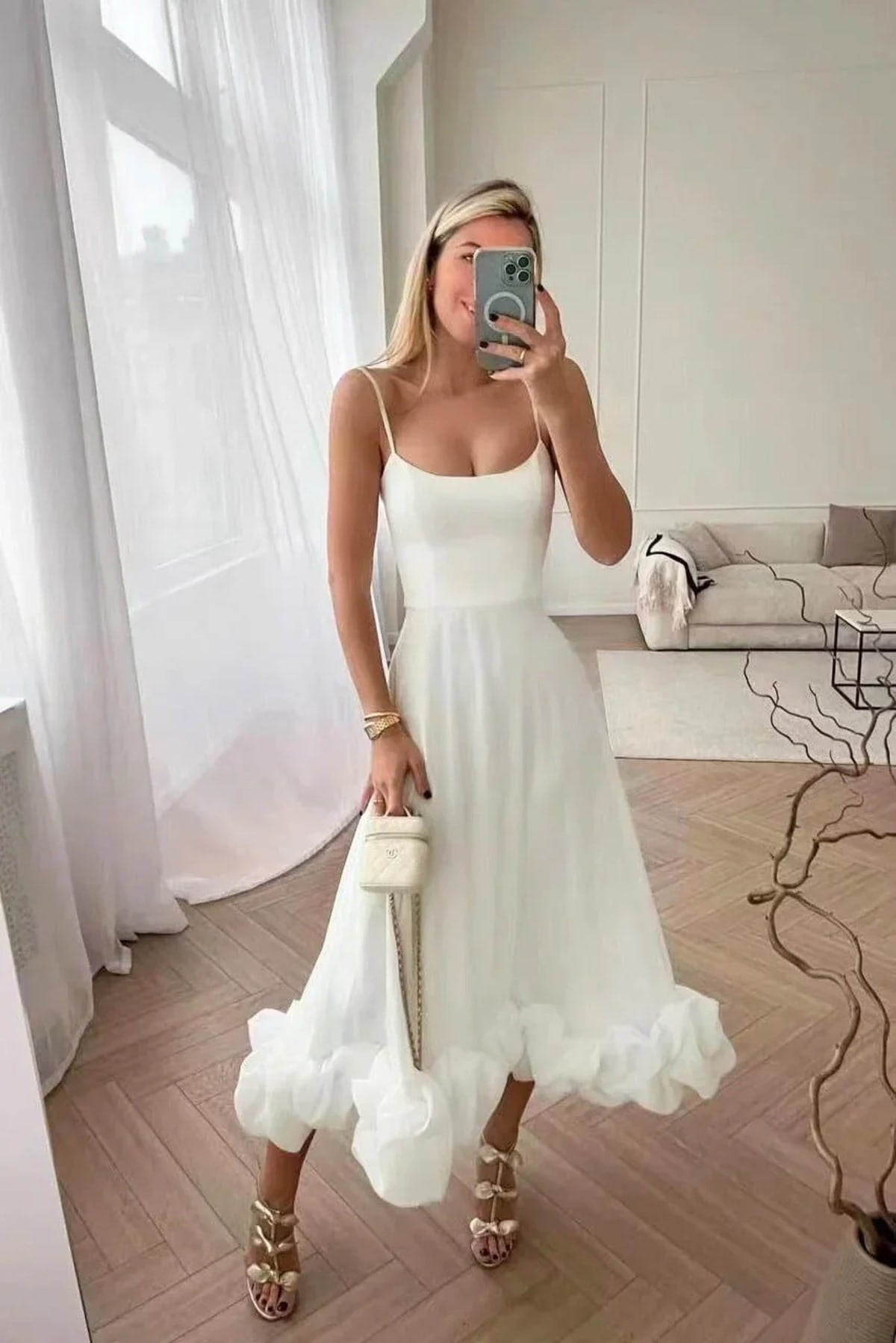 Woman in spaghetti strap midi dress with ruffled hem and fitted bodice.