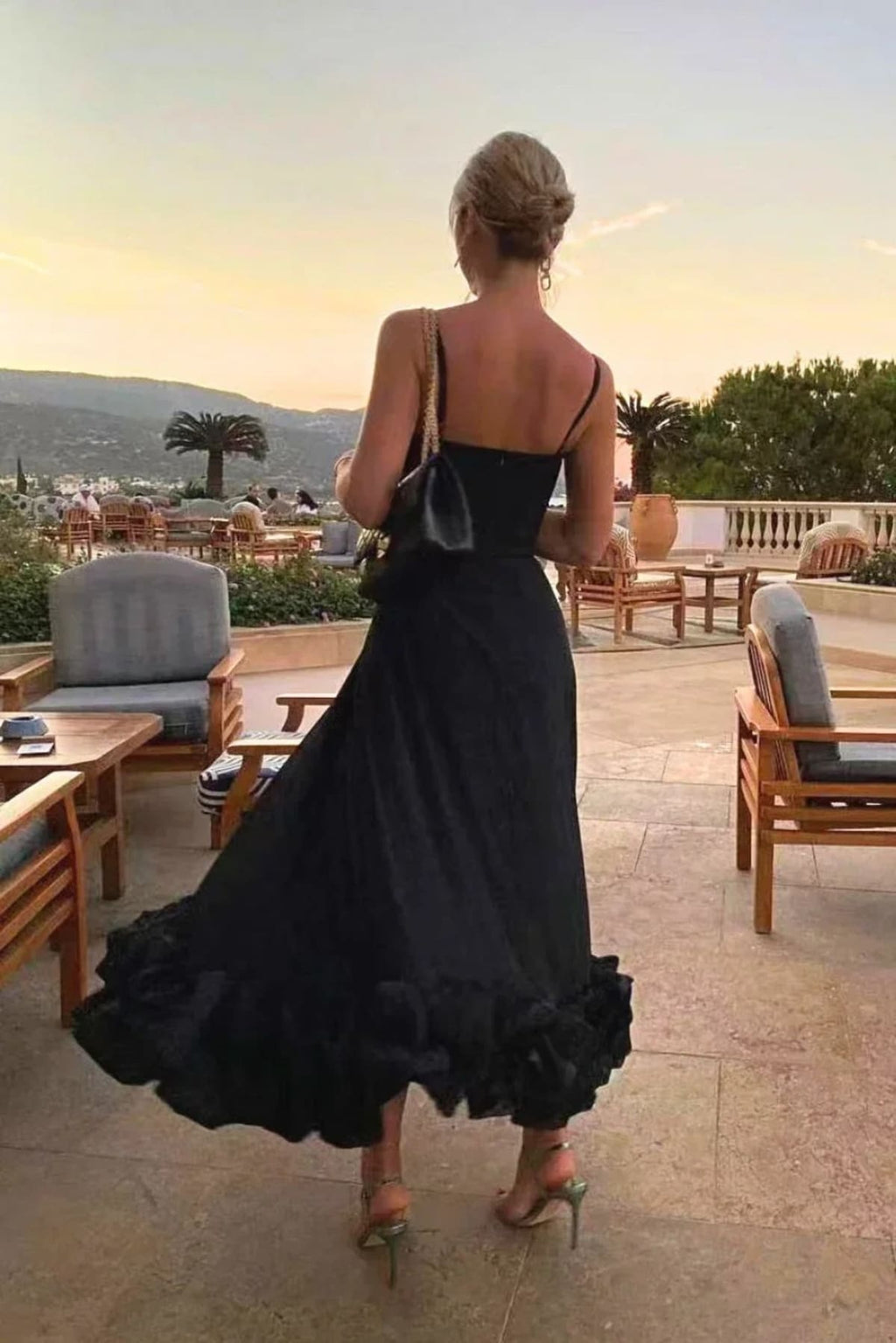 Woman in spaghetti strap midi dress with ruffled hem and fitted bodice.