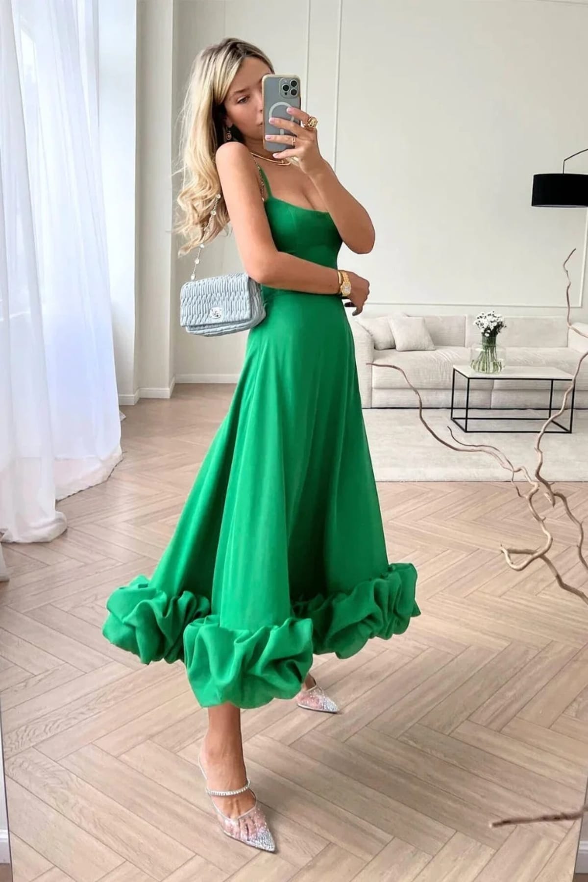 Woman in spaghetti strap midi dress with ruffled hem and fitted bodice.