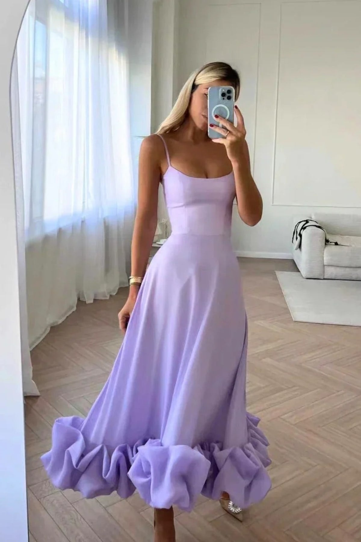 Woman in spaghetti strap midi dress with ruffled hem and fitted bodice.
