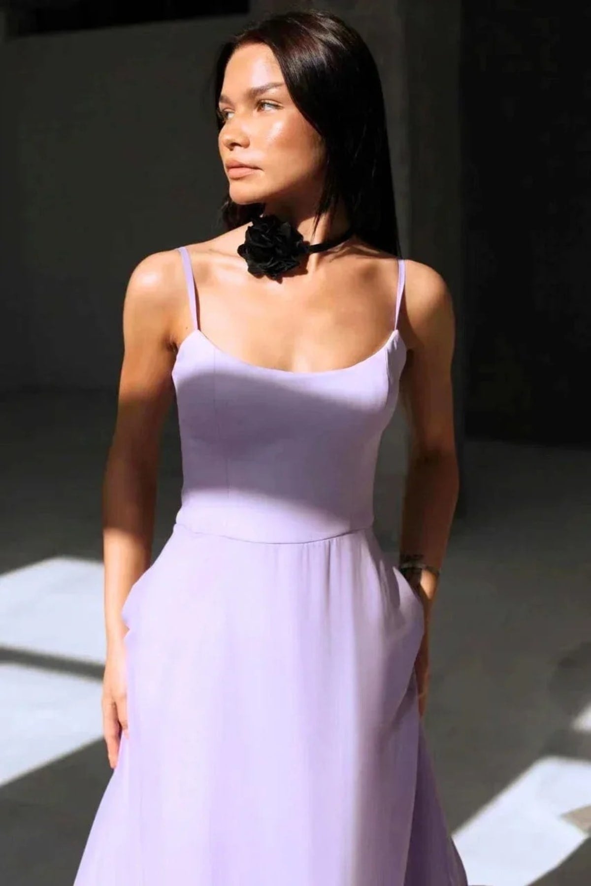 Woman in spaghetti strap midi dress with ruffled hem and fitted bodice.