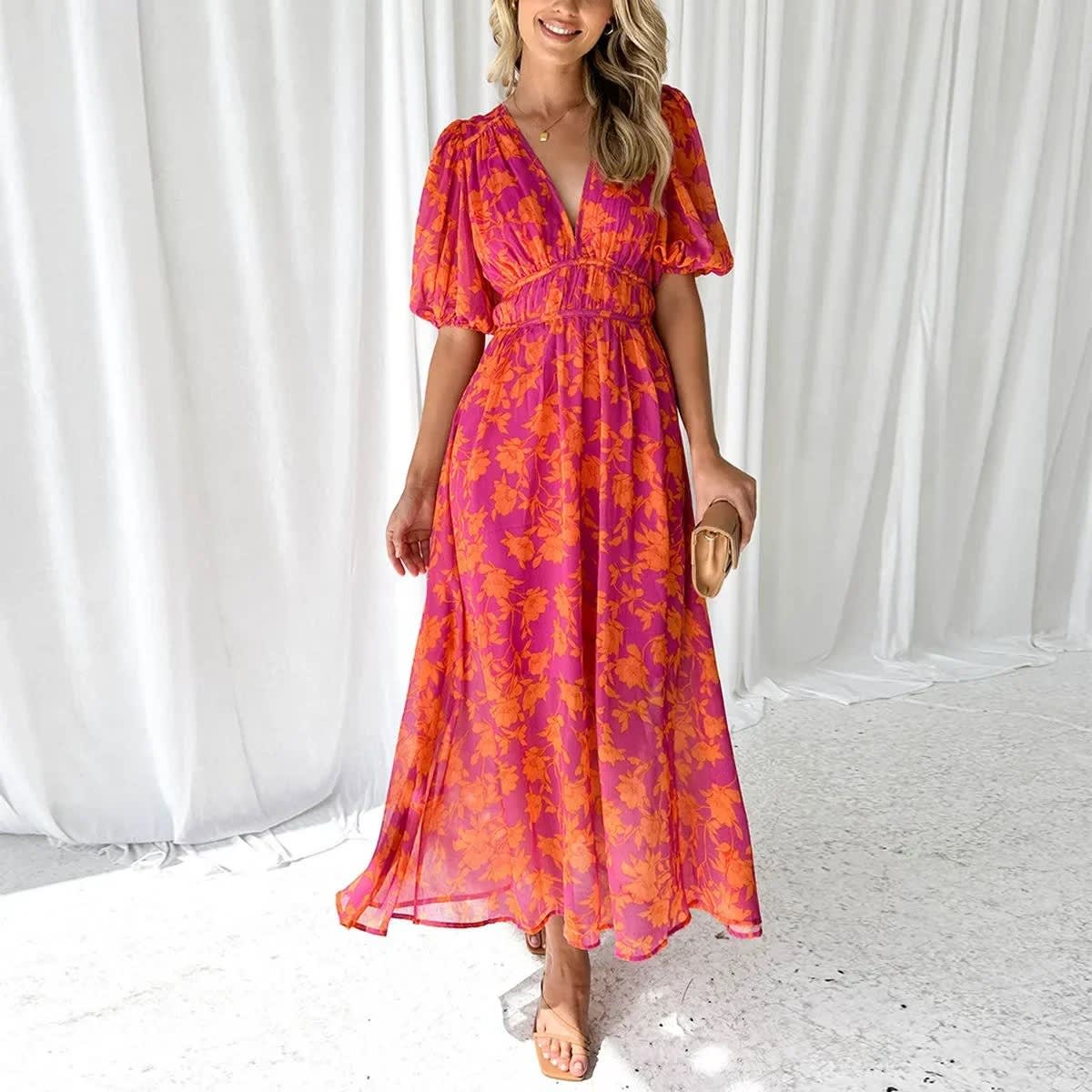 Woman modeling vibrant floral midi dress with V-neck and puff sleeves.
